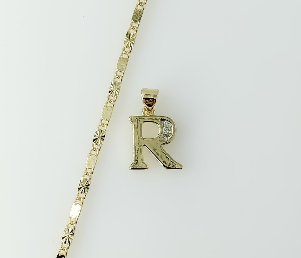 Dainty gold plated letter "R" star pendant on a chain necklace.